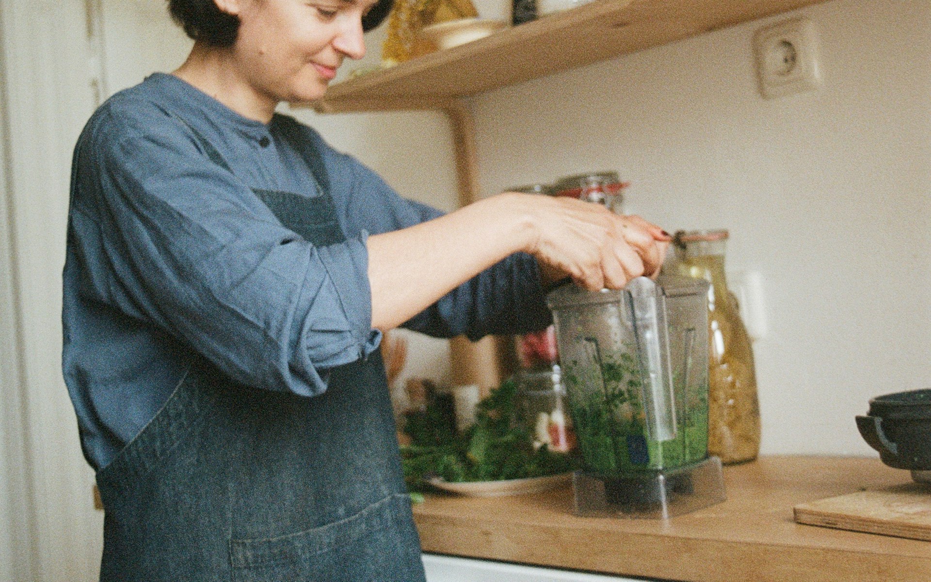 Frau befüllt Mixer in Küche